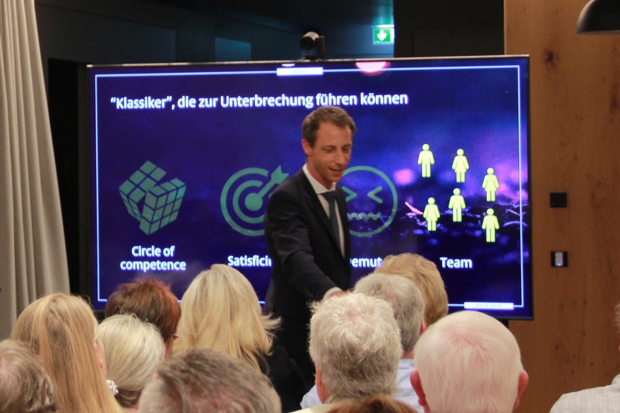 Finanzpsychologe Florian Kolb spricht vor interessiertem Publikum über die Verbindung von Emotion und Rationalität bei Investmententscheidungen und bezieht die Gäste mit ein.